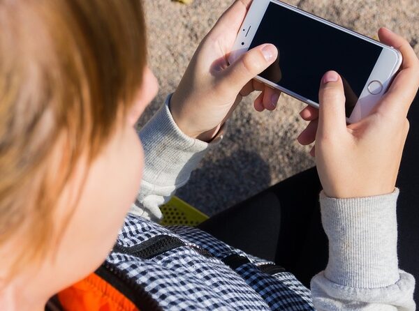 Un infant interactua amb un telèfon mòbil.